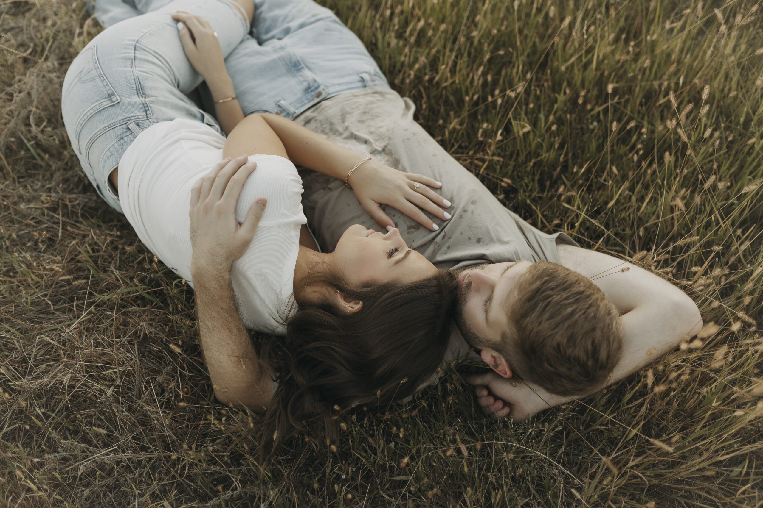 couple laying together on ground lakeside